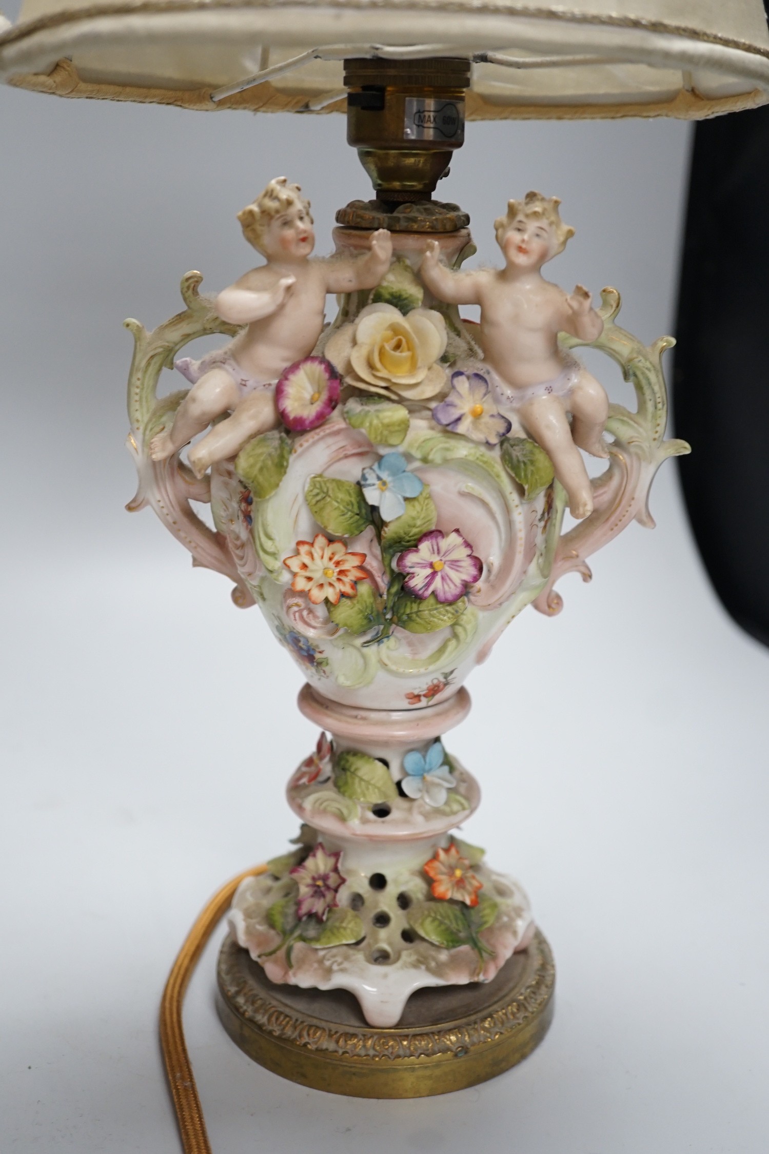 A pair of German porcelain flower encrusted lamps, height 24cm